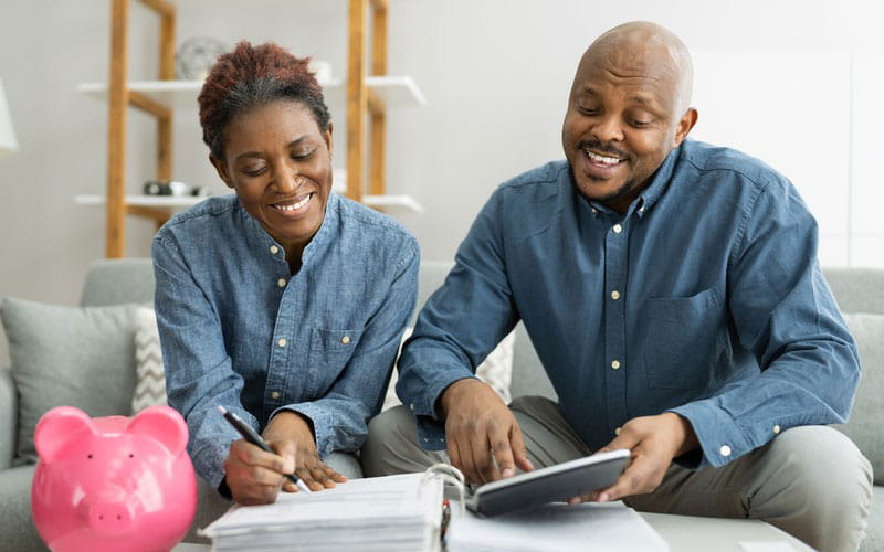 Smiling black couple look over paperwork 